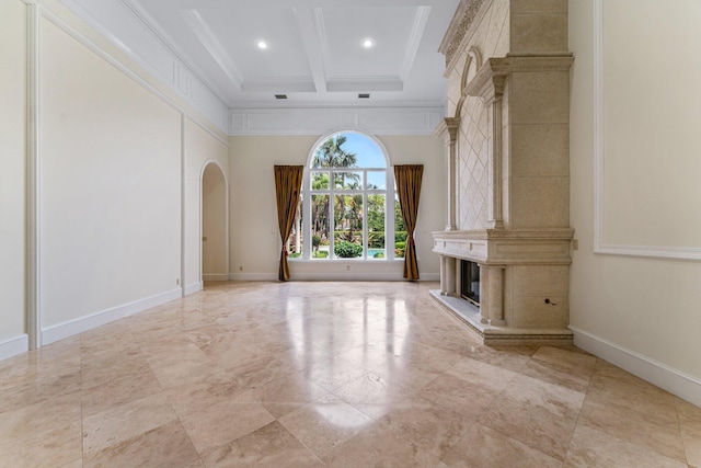 interior space featuring coffered ceiling, ornamental molding, beam ceiling, and a fireplace