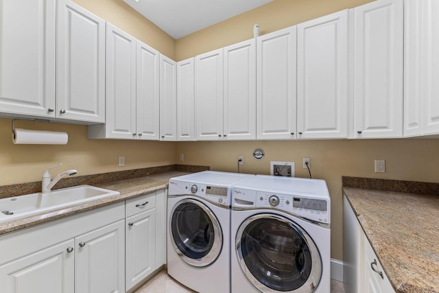 clothes washing area with washer and dryer, cabinets, sink, and light tile patterned flooring