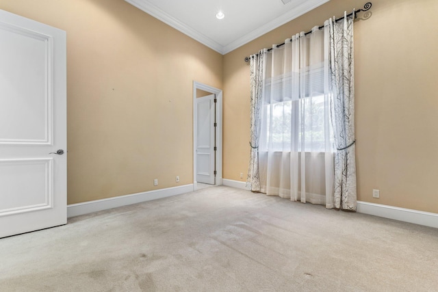 empty room with ornamental molding and light colored carpet