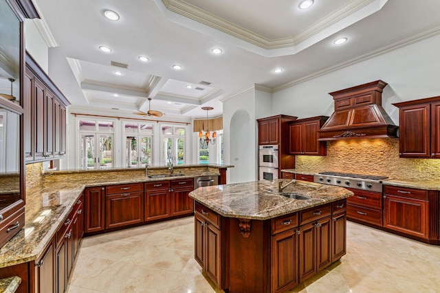 kitchen featuring custom range hood, decorative light fixtures, stainless steel appliances, an island with sink, and tasteful backsplash