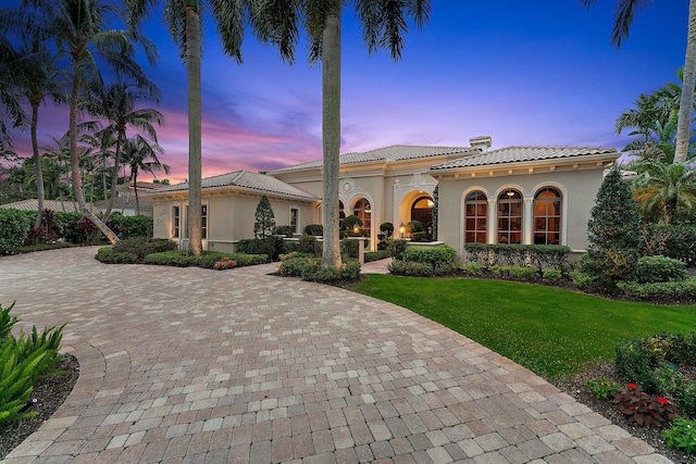 mediterranean / spanish house featuring a yard