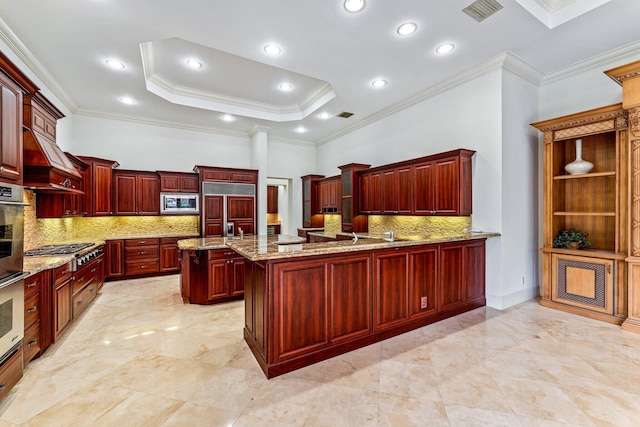 kitchen with light stone counters, kitchen peninsula, built in appliances, decorative backsplash, and ornamental molding