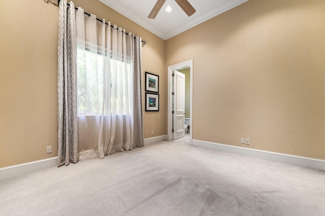 spare room with light colored carpet, ceiling fan, and ornamental molding