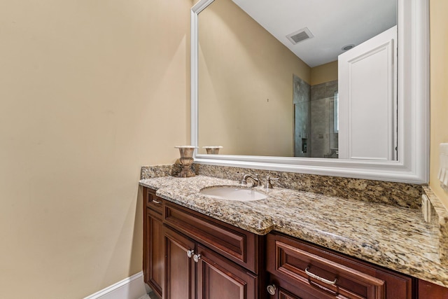 bathroom featuring a shower with door and vanity