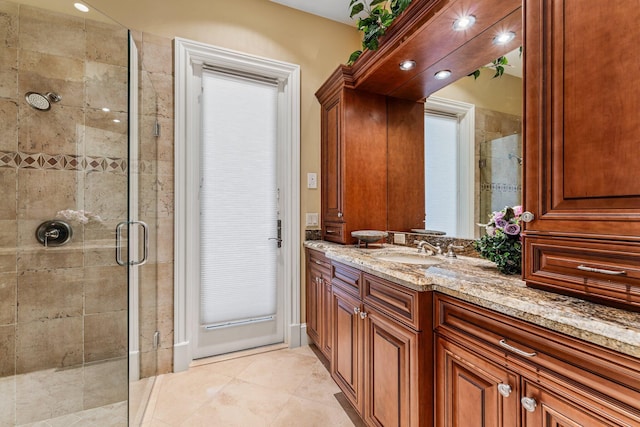 bathroom with vanity, a shower with shower door, and tile patterned floors