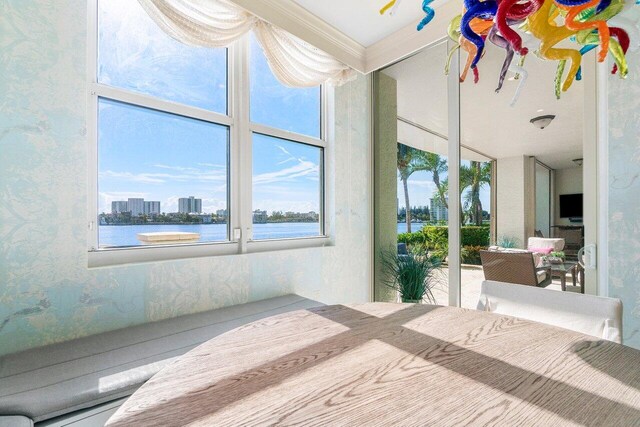 unfurnished bedroom with a water view and crown molding