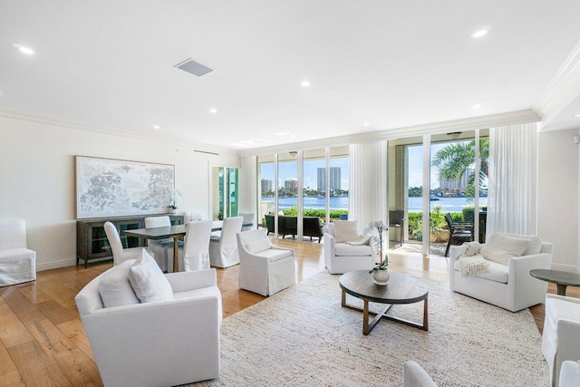 living room featuring expansive windows, light hardwood / wood-style floors, and ornamental molding