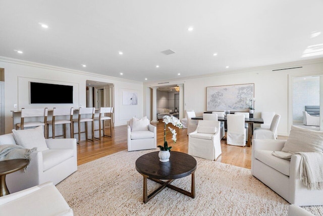 living room featuring light hardwood / wood-style flooring and ornamental molding