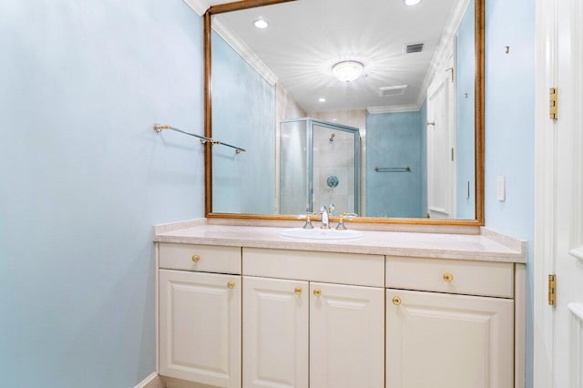 bathroom with vanity, a shower with shower door, and ornamental molding