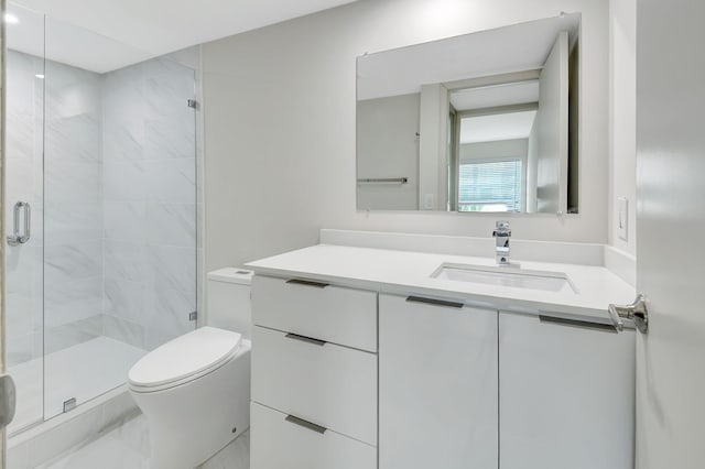 bathroom with vanity, toilet, and a shower with shower door