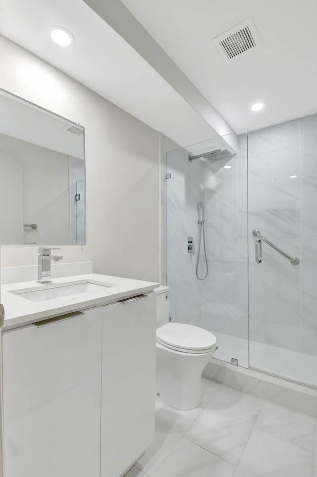 bathroom with vanity, toilet, and a shower with door