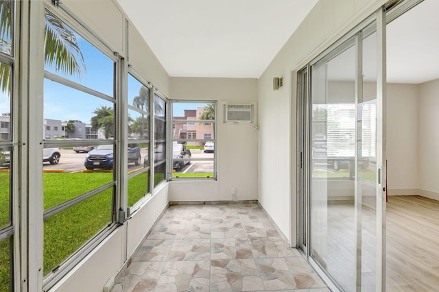 unfurnished sunroom with plenty of natural light and a wall mounted AC