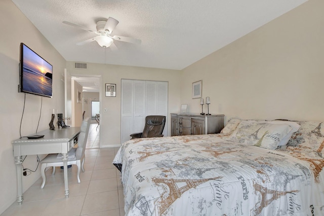 bedroom featuring a textured ceiling, ceiling fan, light tile patterned floors, and a closet