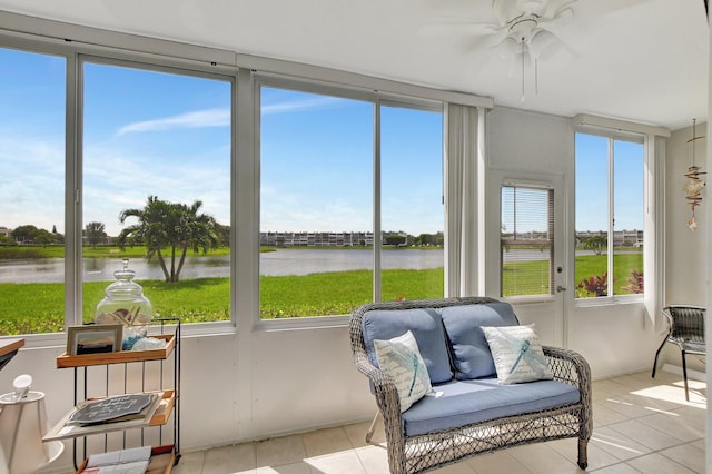 sunroom / solarium with a healthy amount of sunlight, ceiling fan, and a water view