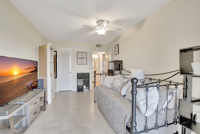 tiled bedroom with a textured ceiling and ceiling fan