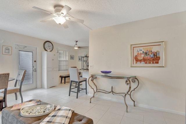 living room with a textured ceiling, light tile patterned floors, and ceiling fan