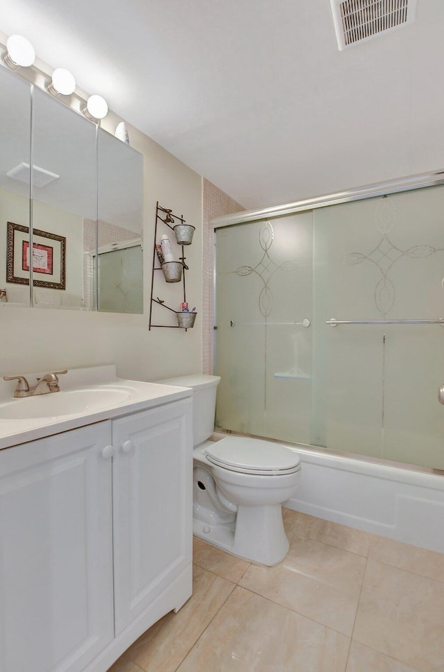 full bathroom featuring combined bath / shower with glass door, vanity, toilet, and tile patterned floors