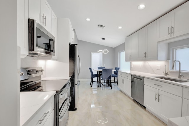 kitchen with plenty of natural light, sink, appliances with stainless steel finishes, and white cabinets