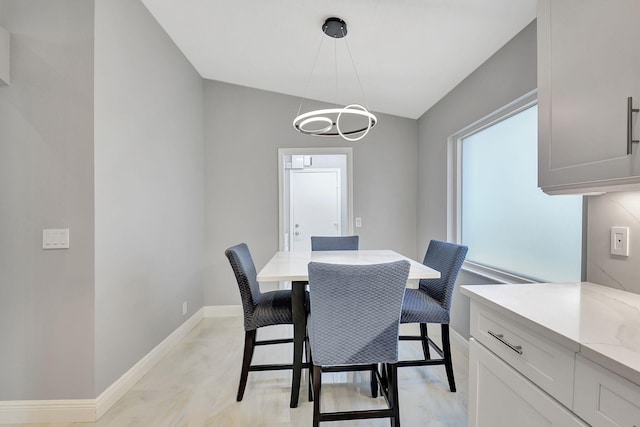 dining room with a chandelier and vaulted ceiling