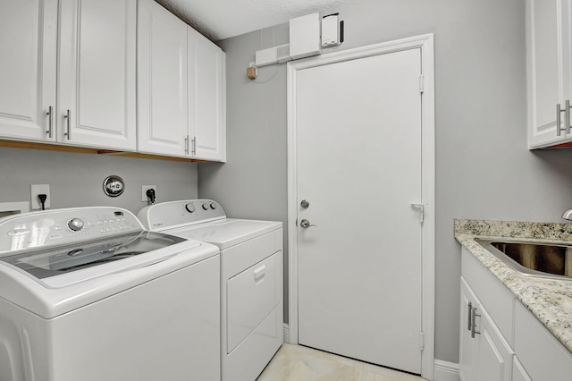 laundry room with washer and clothes dryer, cabinets, and sink