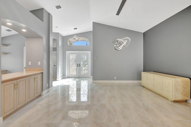 interior space featuring a healthy amount of sunlight, high vaulted ceiling, and french doors