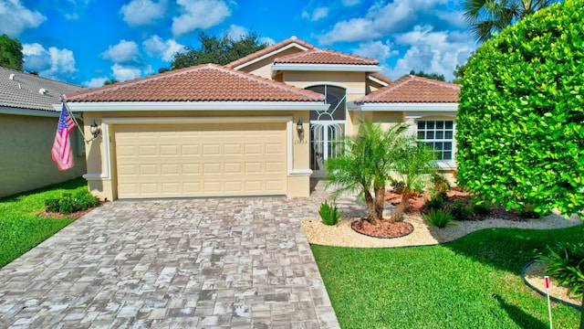 mediterranean / spanish-style home featuring a front yard and a garage