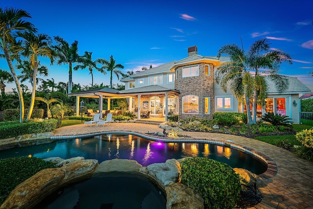 pool at dusk with a patio