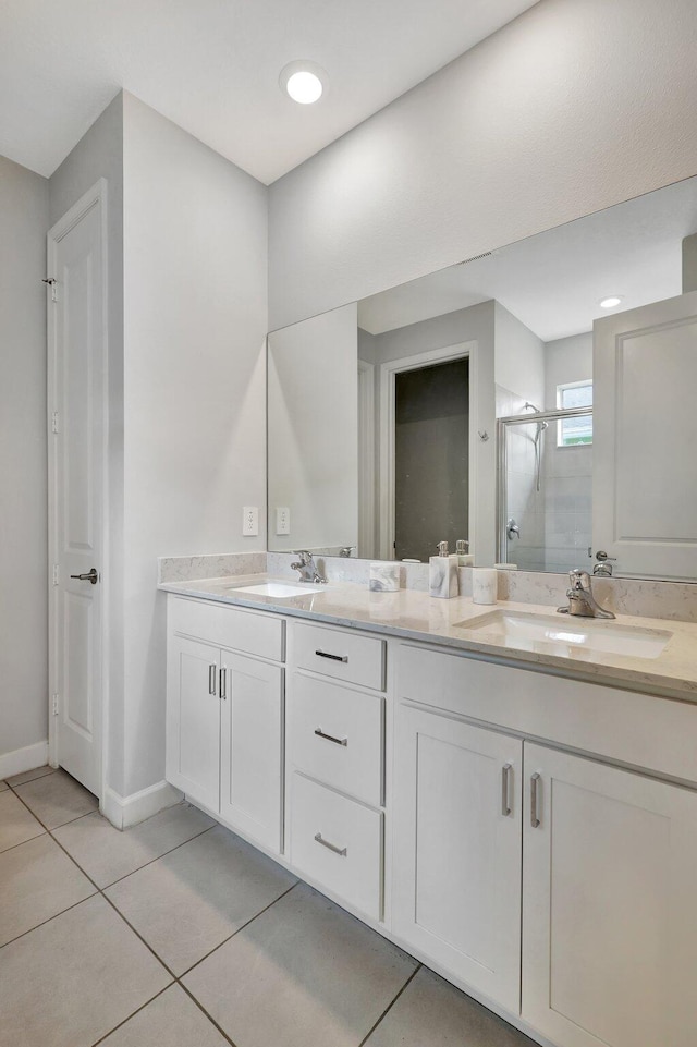 bathroom with tile patterned flooring, vanity, and a shower with door