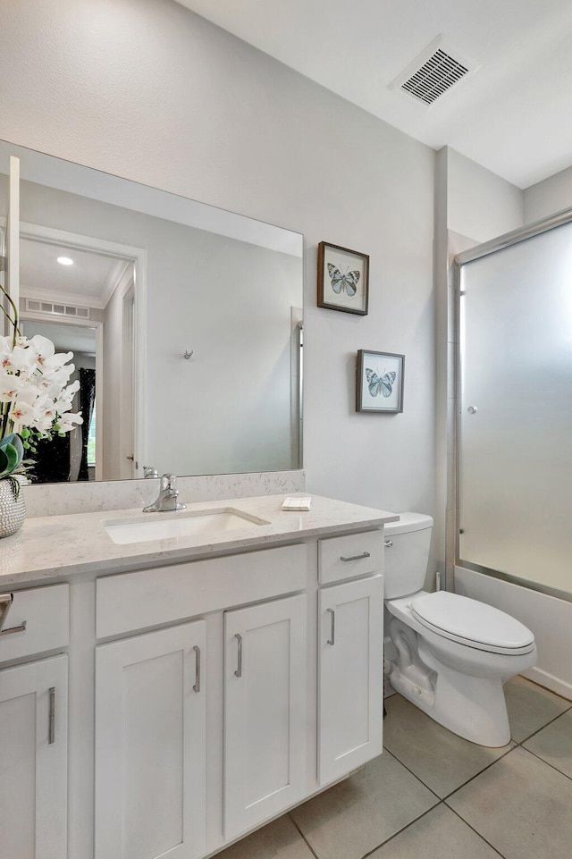 full bathroom featuring vanity, combined bath / shower with glass door, tile patterned floors, and toilet