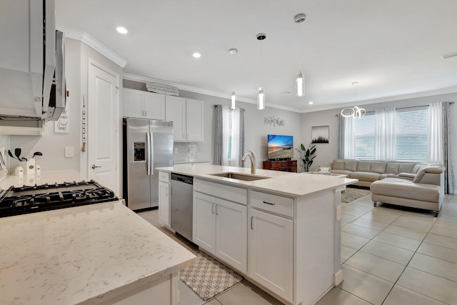 kitchen featuring white cabinetry, hanging light fixtures, stainless steel appliances, and a center island with sink