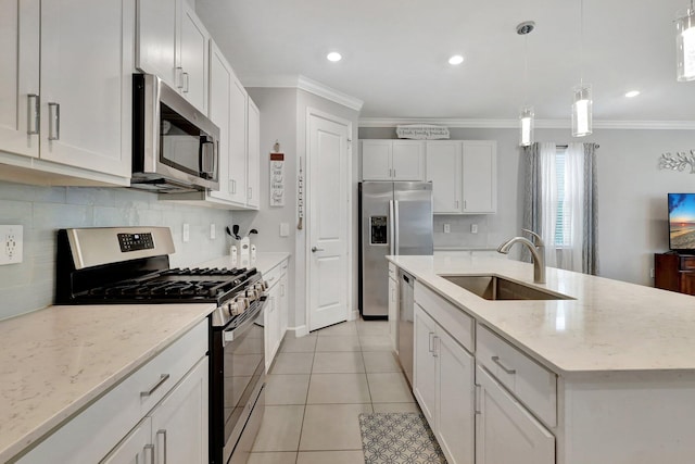 kitchen with pendant lighting, sink, stainless steel appliances, white cabinets, and a center island with sink