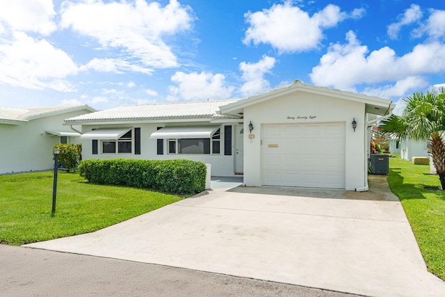 ranch-style house featuring concrete driveway, a tile roof, an attached garage, a front lawn, and stucco siding