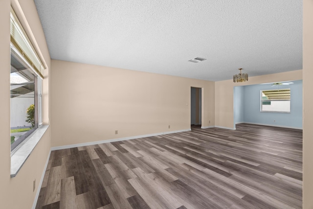 2078 SW 13th Ter, Boynton Beach, FL 33426 - spare room with a chandelier, a textured ceiling, wood finished floors, and baseboards