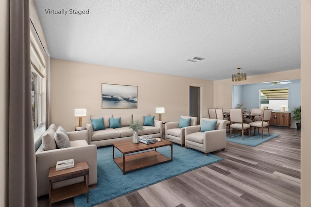 2078 SW 13th Ter, Boynton Beach, FL 33426 - living room featuring wood finished floors, a textured ceiling, and a chandelier