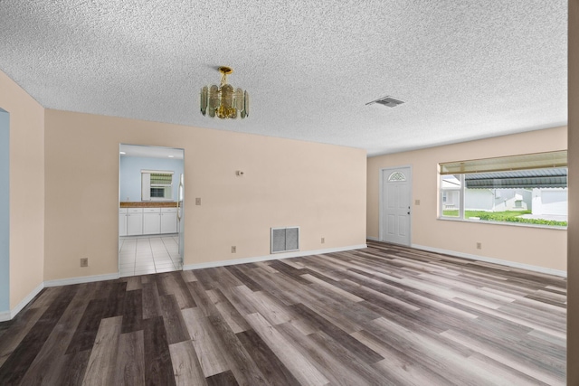 2078 SW 13th Ter, Boynton Beach, FL 33426 - unfurnished living room with wood finished floors, a chandelier, a textured ceiling, and baseboards