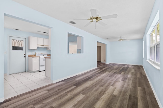 2078 SW 13th Ter, Boynton Beach, FL 33426 - unfurnished living room with a ceiling fan, light wood-style floors, and baseboards