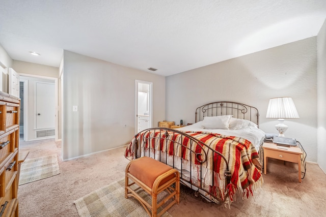 bedroom featuring carpet flooring, connected bathroom, and a textured ceiling