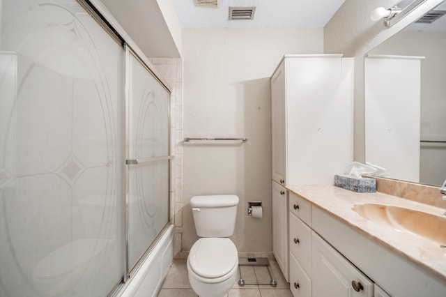 full bathroom featuring shower / bath combination with glass door, tile patterned flooring, toilet, and vanity