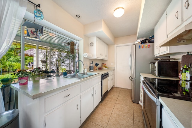 kitchen featuring white cabinetry, a textured ceiling, light tile patterned floors, stainless steel appliances, and sink