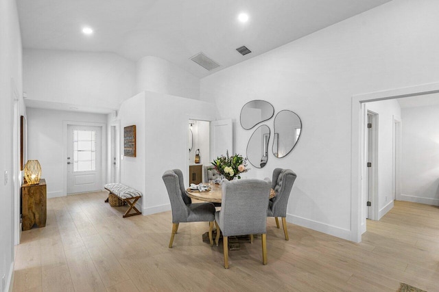 dining space featuring light hardwood / wood-style floors and high vaulted ceiling