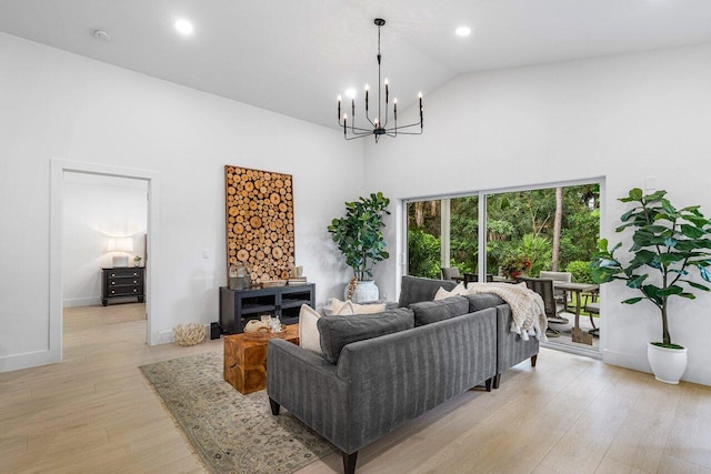 living room with light hardwood / wood-style flooring, a chandelier, and high vaulted ceiling