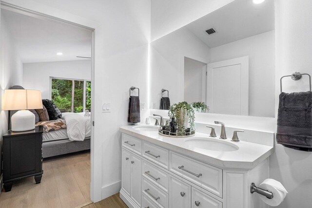 bathroom featuring vanity, lofted ceiling, and hardwood / wood-style floors