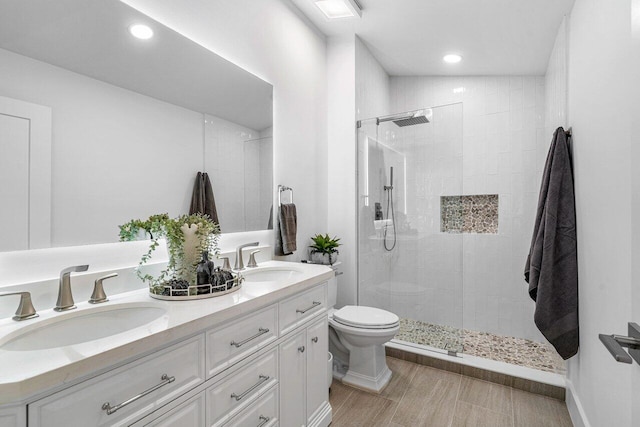 bathroom with a tile shower, lofted ceiling, vanity, and toilet