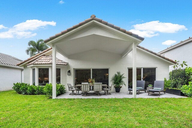 rear view of property with a lawn and a patio area