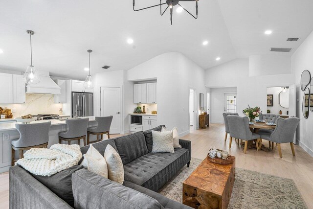 living room featuring high vaulted ceiling and light wood-type flooring