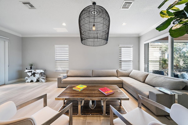 living room with a wealth of natural light, crown molding, and light wood-type flooring