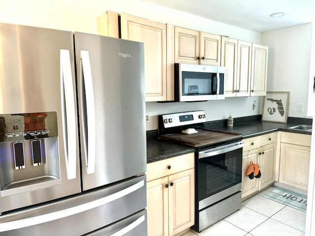 kitchen featuring stainless steel appliances and light tile patterned floors