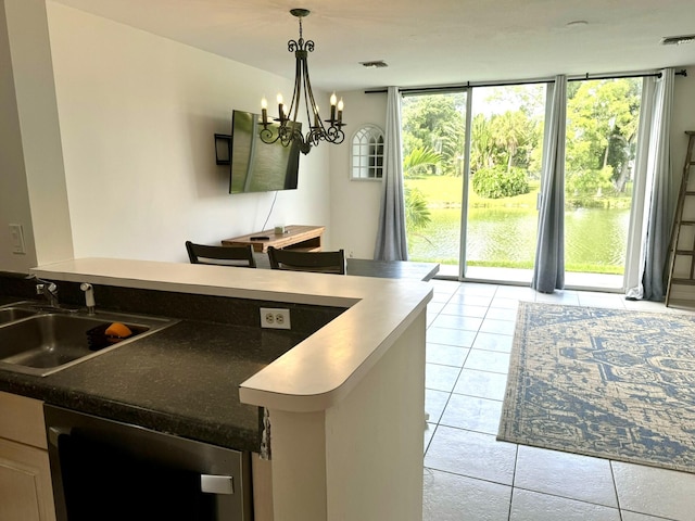 kitchen featuring hanging light fixtures, light tile patterned floors, stainless steel dishwasher, sink, and a notable chandelier