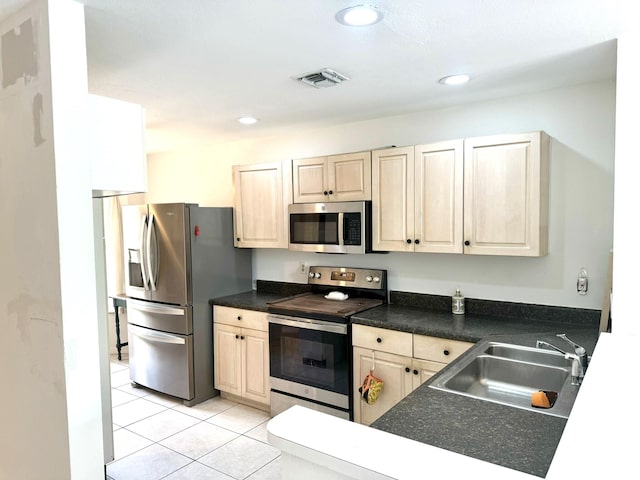 kitchen featuring appliances with stainless steel finishes, light tile patterned flooring, and sink