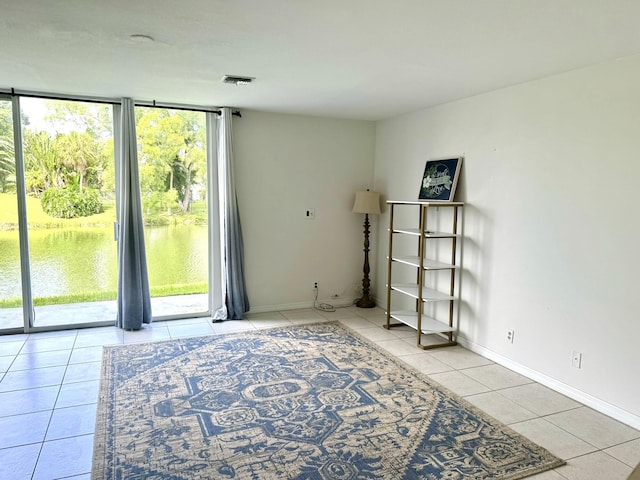 interior space featuring a water view and light tile patterned floors